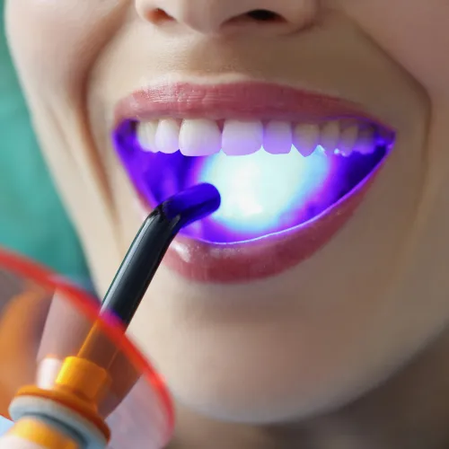 Blue light shining on woman's smile.