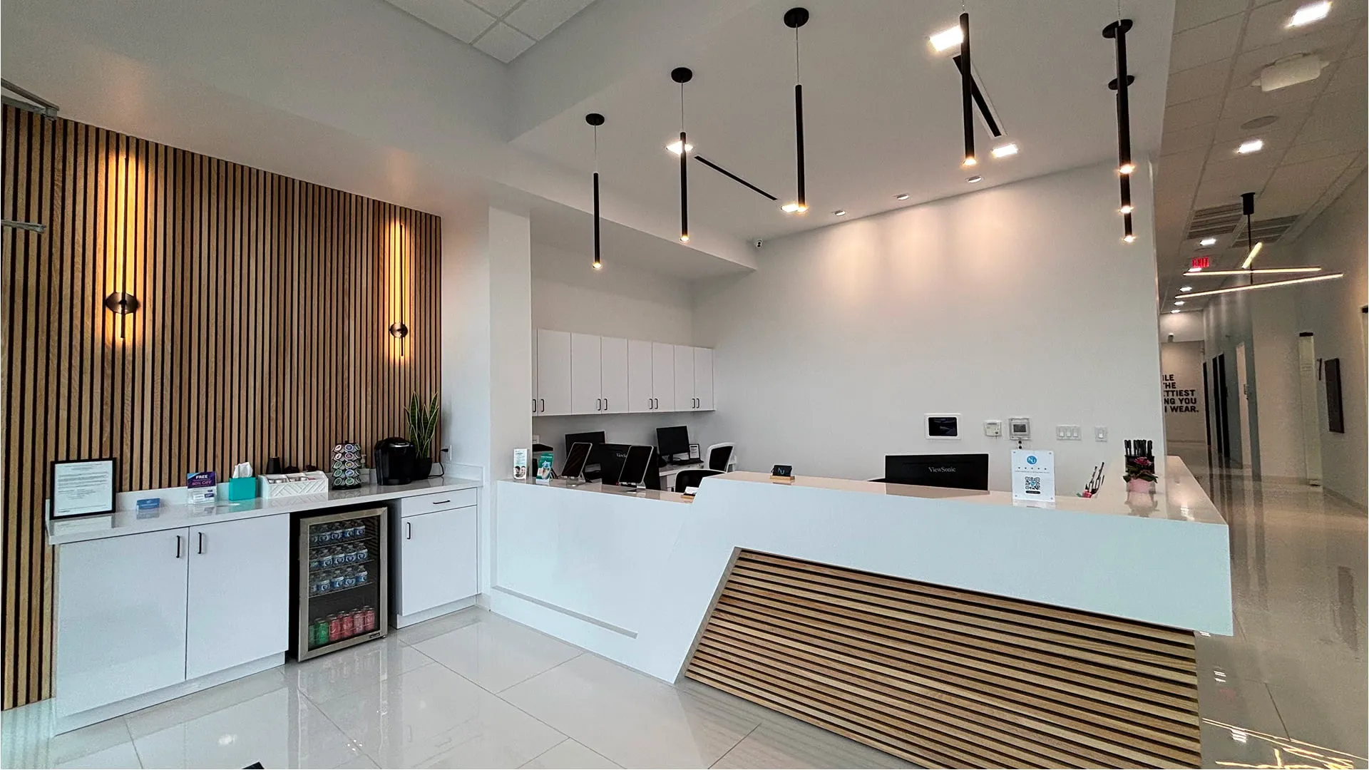 Nu Dentistry reception area with wood slat accent wall and modern pendant lighting