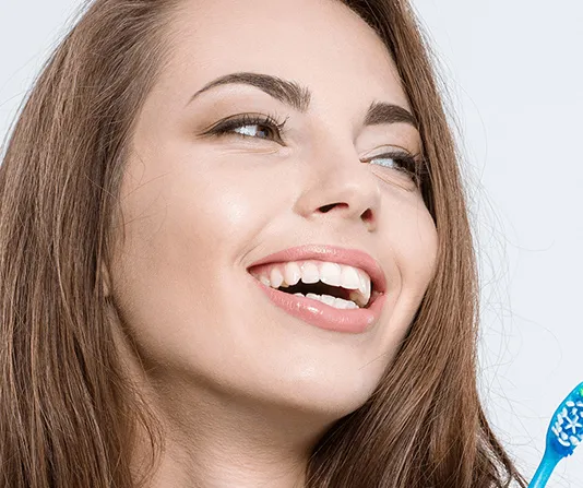 Cosmetic dentistry patient smiling and singing with a toothbrush