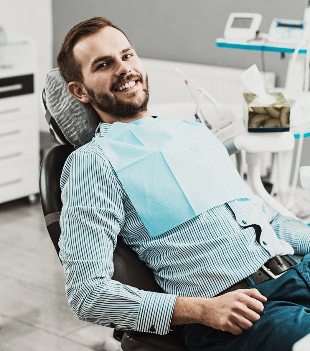 An image of a smiling man on the dental chair 