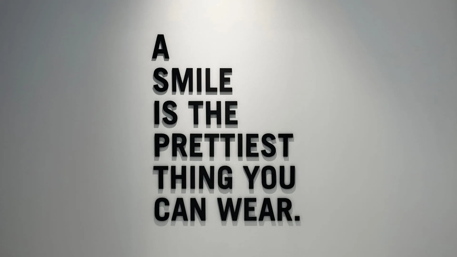 Wall sign reading "A Smile Is The Prettiest Thing You Can Wear"