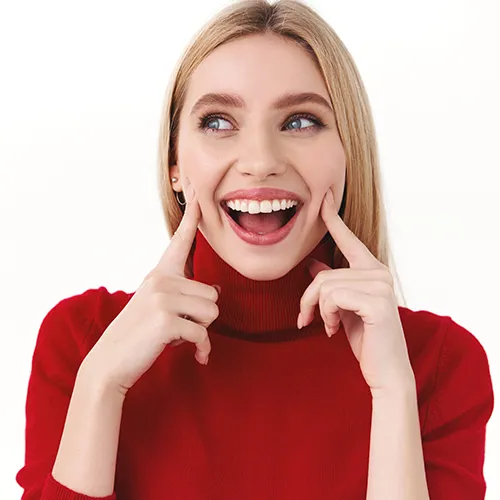 Woman pointing at her smile.