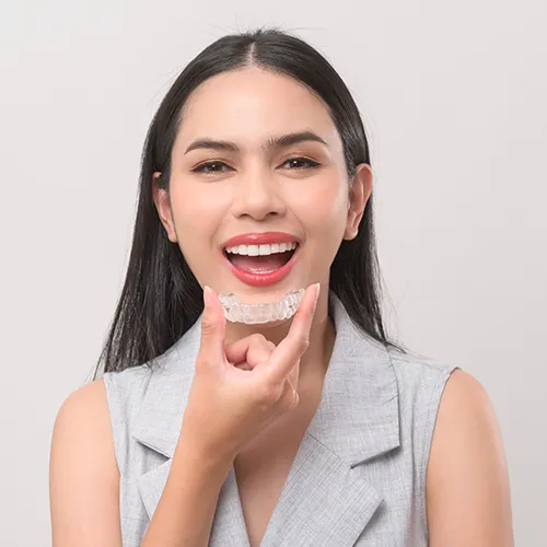 woman putting clear aligner in mouth