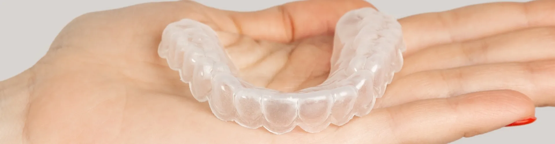 Clear aligner in the palm of a hand.