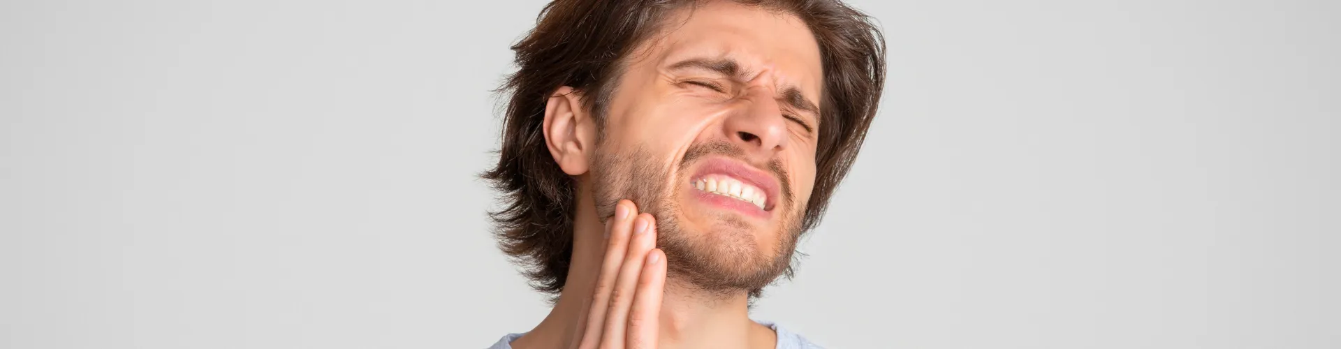 Man holding his jaw in pain.
